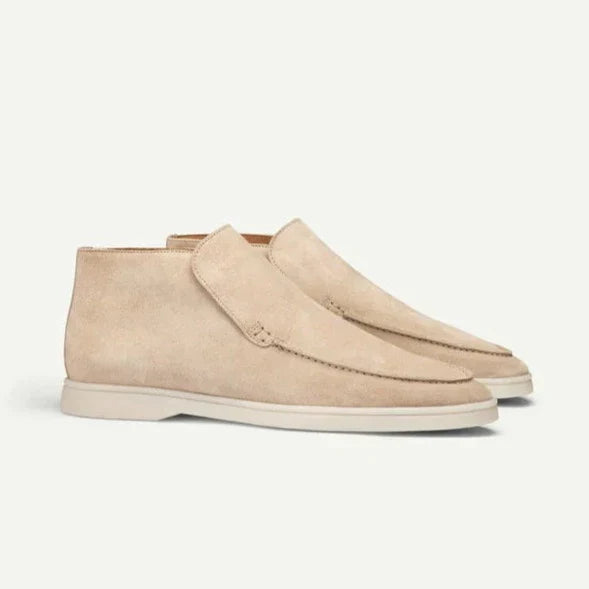 Pair of beige suede shoes on a light gray background