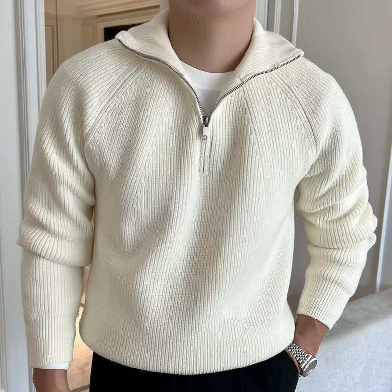 Person wearing a cream-colored zip-up sweater against a neutral background