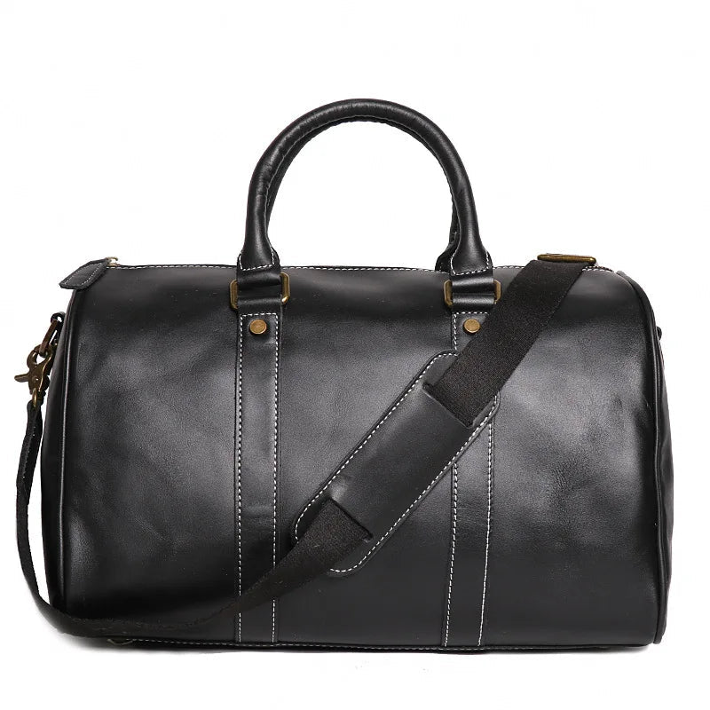 Black leather duffel bag with a shoulder strap on a white background