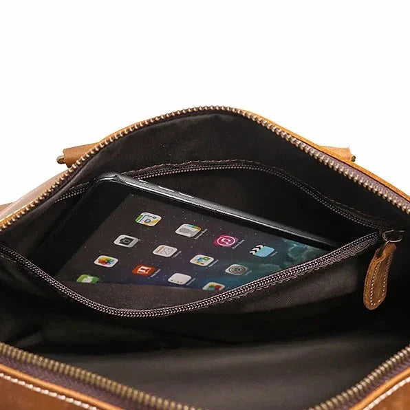 Brown leather bag with a tablet inside on a white background