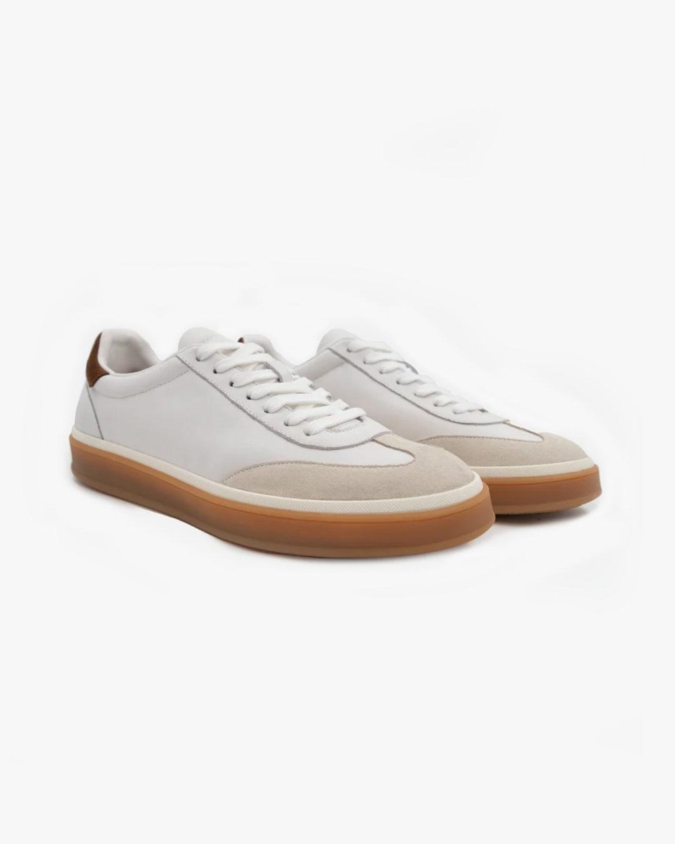 White sneakers with brown soles on a light gray background