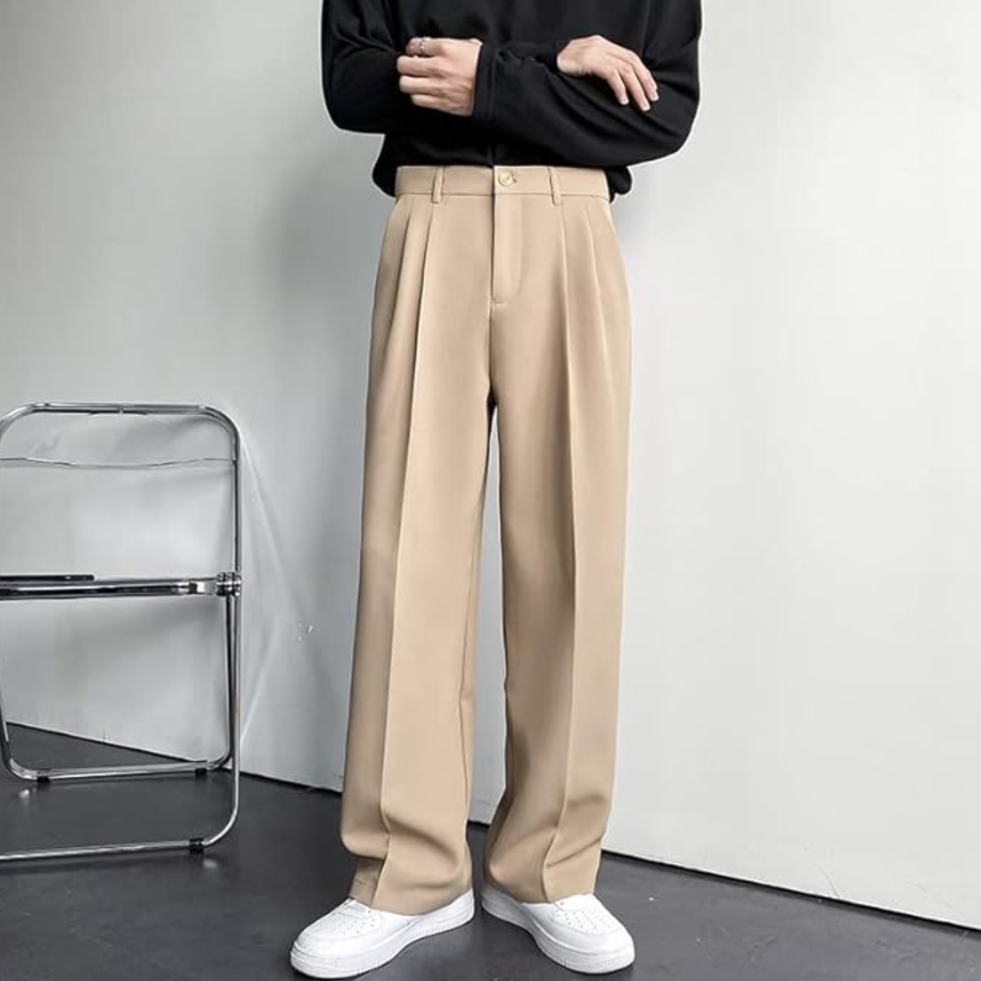 Person wearing beige pants and white shoes in a minimalistic setting