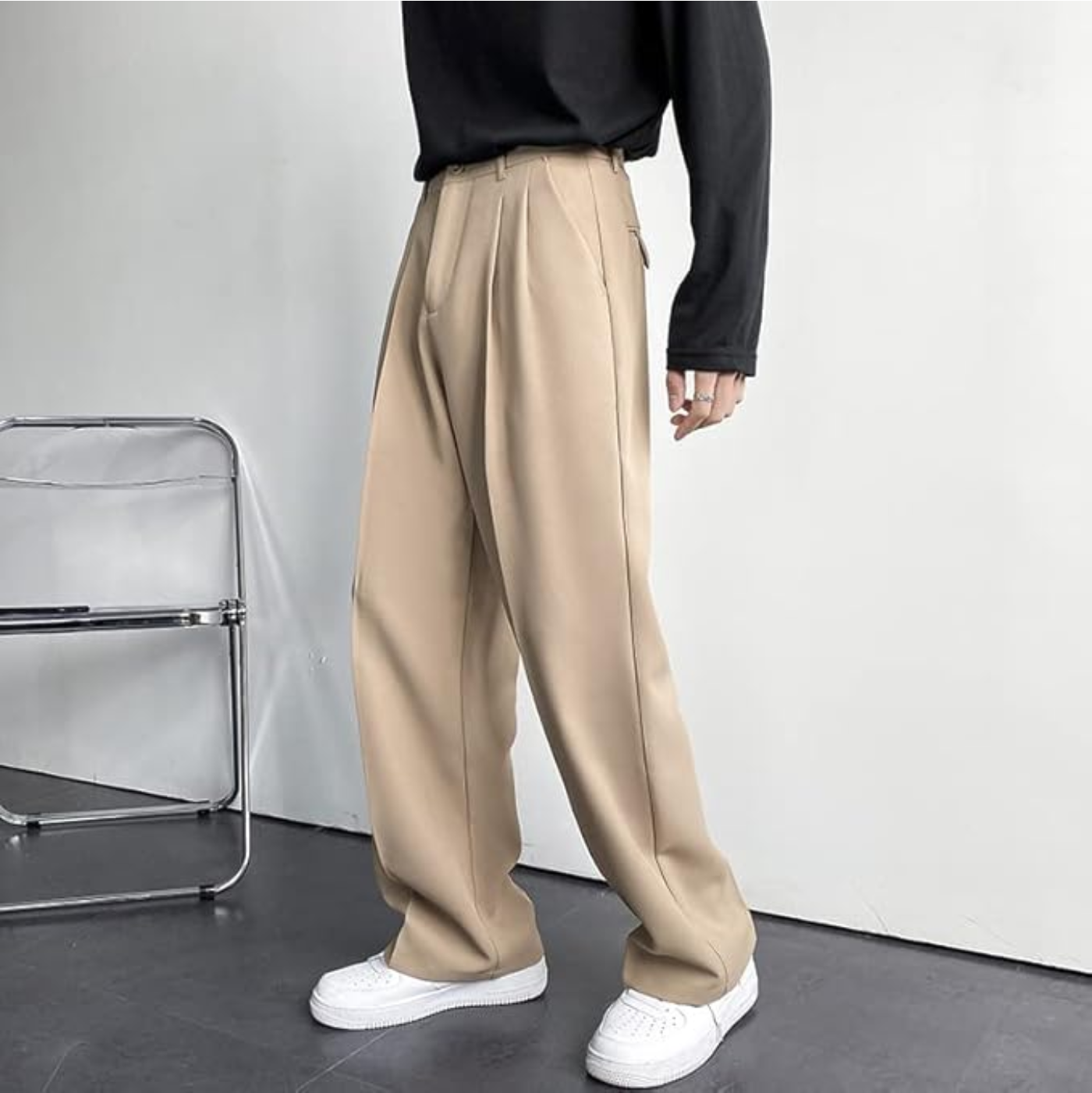 Person wearing beige pants and white shoes in a minimalistic setting
