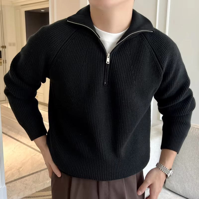 Person wearing a black zip-up sweater in an indoor setting