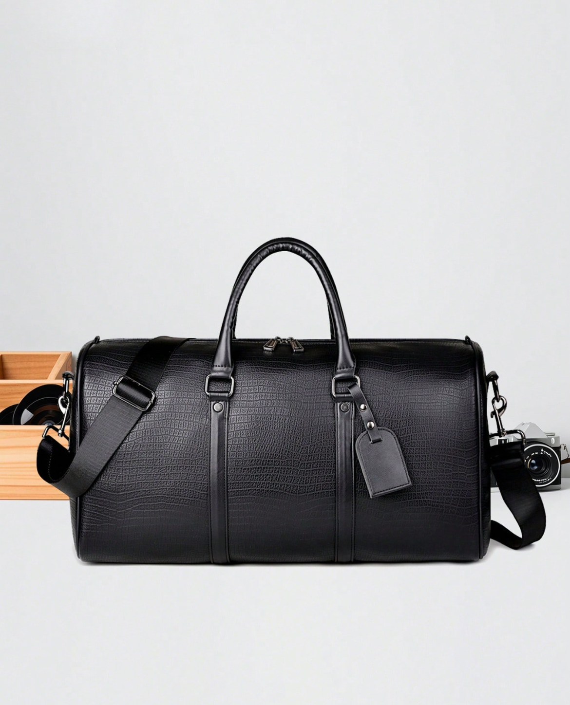 Black leather duffel bag on a light gray background