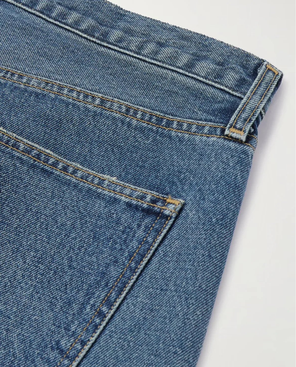 Close-up of blue denim jeans on a light gray background