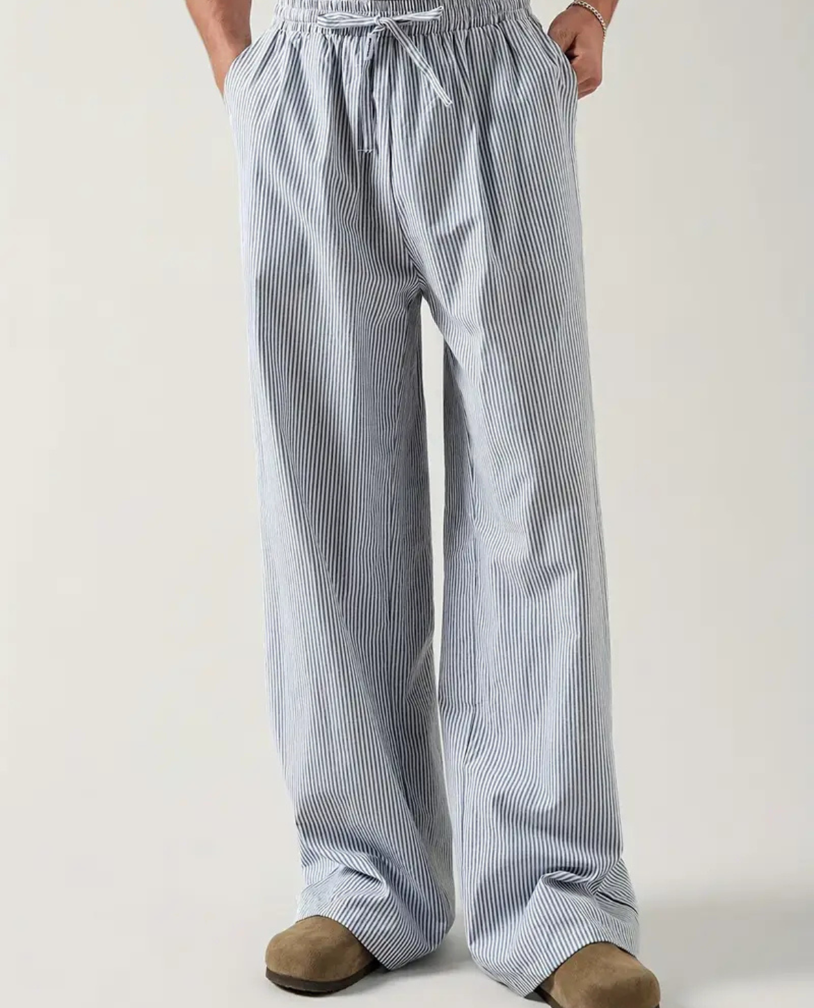 Person wearing blue and white striped pants on a plain background